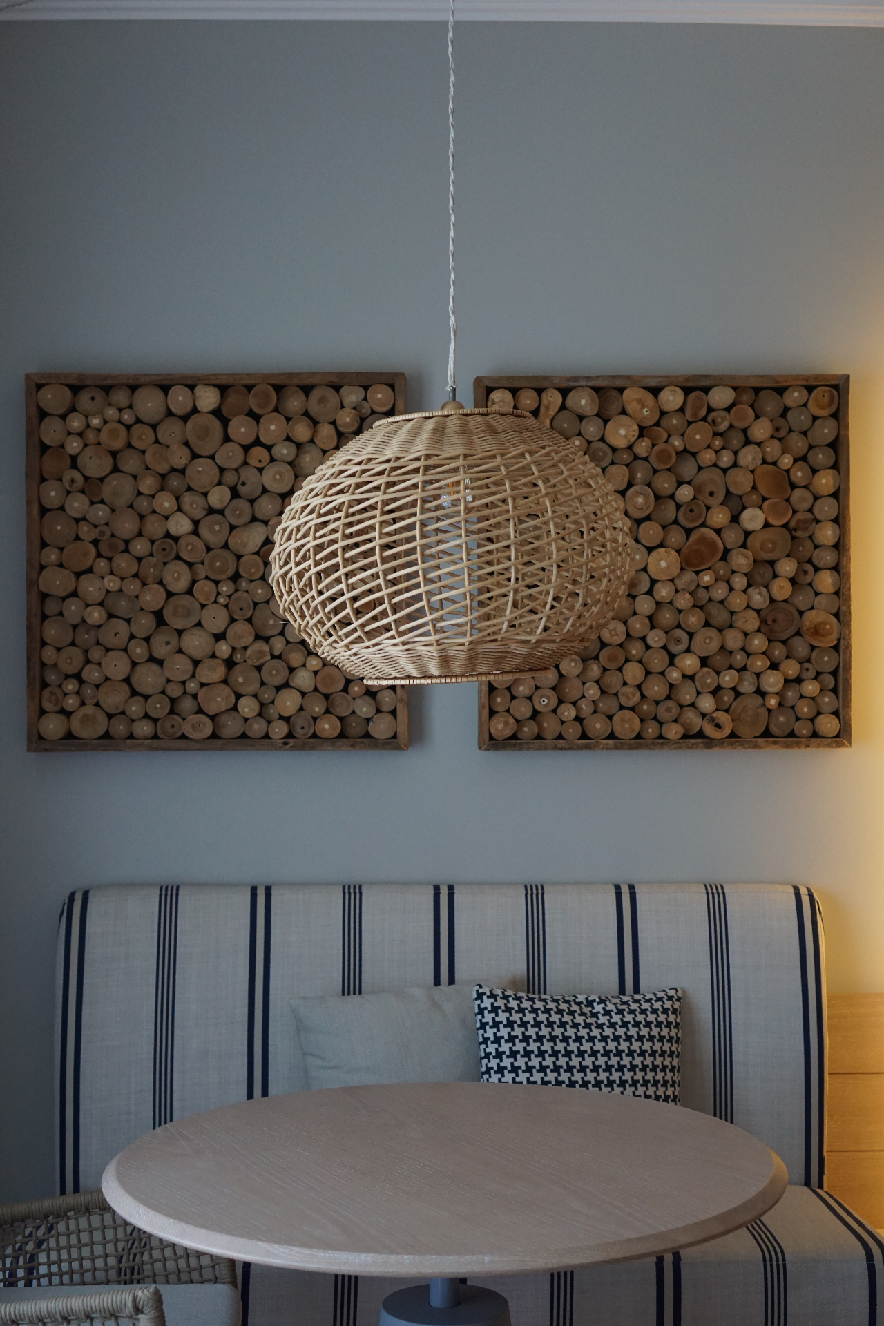 Rattan pendant lamp and natural wood wall art in a hotel suite