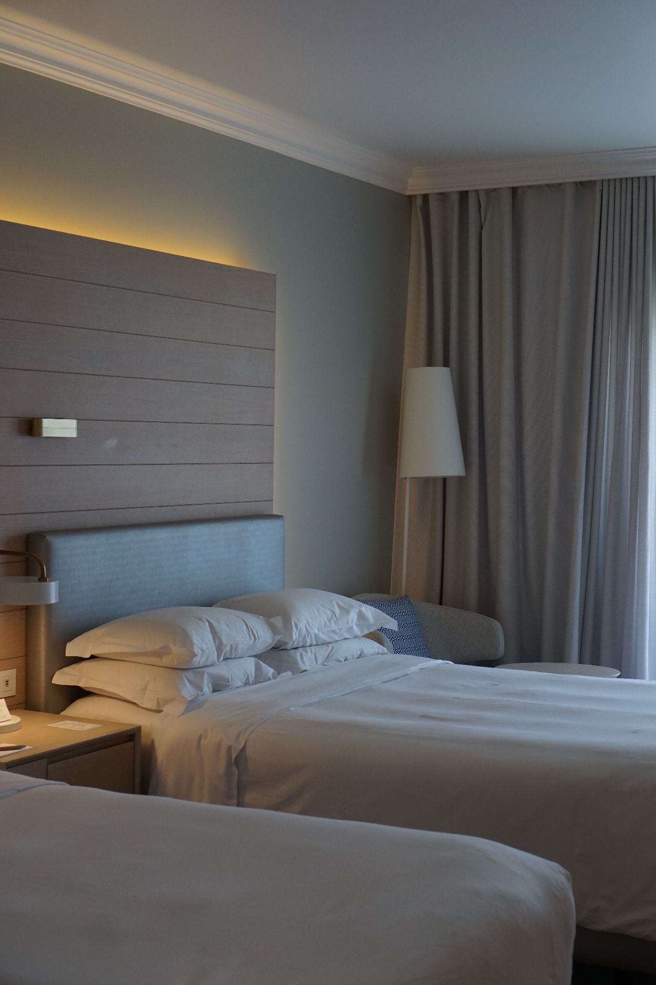 Softly lit hotel suite with crisp white linen beds